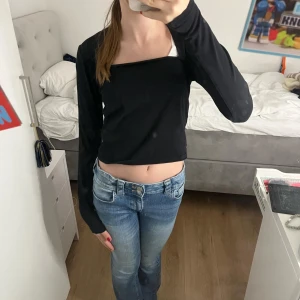 Svart långärmad topp från H&M - Snygg svart långärmad topp från H&M med en stilren design. Perfekt för en casual look eller att klä upp med accessoarer. Toppen har en åtsittande passform och är tillverkad i ett mjukt material.