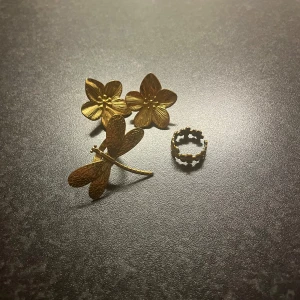 Smycken  - Et par blom örhängen, en trollslända ring och en ring med blommor. Allt 80 kr , är i färgen guld , köpt från Temu 