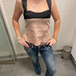 Silkes topp - Det är en ljus rosa och svart silkes topp som går att knyta i bak❤️Jag säljer denna för att jag behöver pengar🤭 Tröjan passar alla storlekar mellan XXS-S för den är stretchiga och går att sjustera om man vill💘💕Den är väldigt skön och luftig pågrund av det silkesliknande materialet!