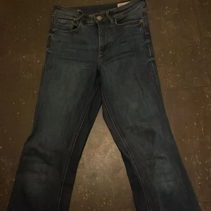 Mörkblå jeans - Snygga mörkblå jeans med klassisk femficksdesign och knappgylf. Perfekta för en avslappnad stil.