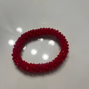 Rött pärlarmband - Snyggt rött armband med glittrande pärlor. Köpt i Turkiet och aldrig använt. 