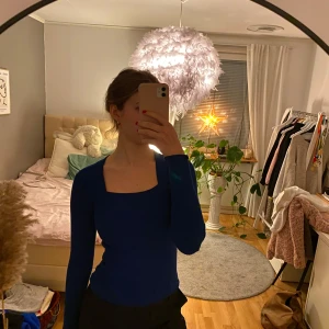 Mörkblå ribbad topp - Säljer en stilren mörkblå ribbad topp med långa ärmar och fyrkantig halsringning. Passar till kjolar och kostymbyxor m.m. Säljer då jag inte använder den längre. Passar lite större str också då den har strech.