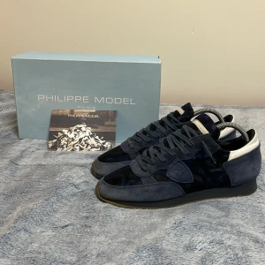 Philippe Model trainers i marin blå - Tja! säljer ett par Snygga Philippe Model trainers i blå💙 mocka med camouflering detaljer. Skorna har en klassisk design med snörning och en bekväm sula. Perfekta för en stilren look🔥med skorna kommer  ett kort av Philippe model 🔥💯 låda ingår ej 🚫om du undrar över något, tveka inte på att fråga ❤️💯
