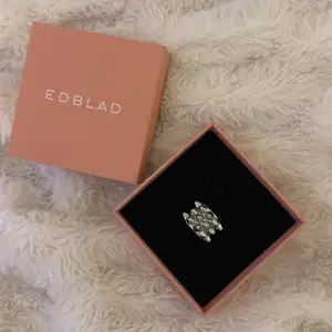 Knappt andvänd. Super snygg och trendig ring från Edblad i silverfärg. Ringen har nitar och är perfekt för att ge en extra touch till din outfit. stolek xs