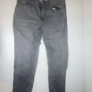 Grå jeans från Zara - Snygga grå jeans från Zara med en klassisk femficksdesign. De har en dragkedja och knapp framtill. Perfekta för en stilren look.