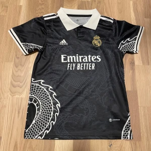Real Madrid Special 23-24 - En fin och väldigt unik Real Madrid special tröja från 2023-2024 säsongen. Den är inte officiell, dock är den i väldigt gott skick, bara använd ett fåtal gånger. Tveka inte på att skicka ett meddelande om du har någon fråga! 😁 (Storleken nedan är barnstorlek)