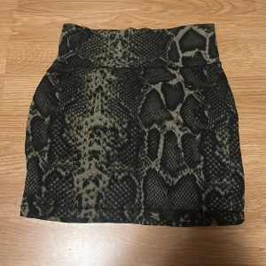 Ormmönstrad kjol - Snygg ormmönstrad kjol från Gina Tricot i storlek XS. Kjolen har en tight passform. Den är i en kort modell och har ett coolt mönster. 💗