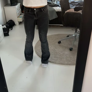 Mörkgråa lågmidjade bootcut jeans - Snygga svarta bootcut jeans med låg midja. Säljer då de inte kommer till användning. Går ner till marken på mig som är 165 och har slitits endast lite vid hälen på ena benet