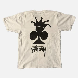 Vit t-shirt från Stüssy med tryck - vit t-shirt från Stüssy med ett stort svart tryck på baksidan och en mindre logga på framsidan