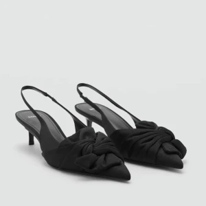 Svarta slingback-pumps med rosett - Eleganta svarta slingback-pumps med spetsig tå och en dekorativ rosett. Helt nya och super bekväma. Är Normalt en 38 men är storlek 37 och den passar super. Helt nya