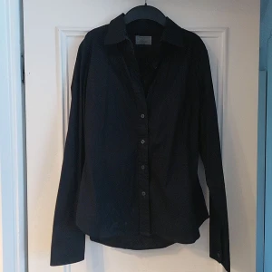 Svart skjorta från Replay - Snygg svart skjorta från Replay med långa ärmar och knappar framtill. Perfekt för en stilren look. Skjortan har en klassisk krage och är tillverkad i ett bekvämt material.