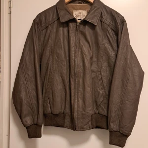 Japansk skinnjacka från Antesco - Snygg brun skinnjacka från Antesco med dragkedja och ribbade muddar. Jackan har en klassisk krage. Insidan är fodrad för extra komfort. Skinnet är riktigt. Storleken är M men den är rätt liten för att vara M så jag skulle säga att den är S. Skriv till 0700135870 om du är intresserad, vi kan ses i T centralen om du vill men jag kan inte skicka genom post. (Vet inte hur haha)