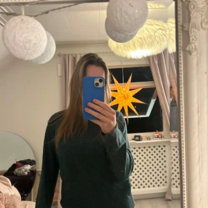 Mörkgrön stickad tröja - Säljer en mysig mörkgrön stickad tröja med långa ärmar. Perfekt för kyliga dagar och enkel att matcha med olika outfits. Tröjan har en klassisk design med rund hals och ribbade muddar. Säljer pga kommer inte till användning.