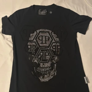 1 tröja för 200kr  - Cool svart t-shirt från Philipp Plein med en stor dödskalle i glittrande detaljer på framsidan. Perfekt för en edgy look. Alla 3 för 1000kr