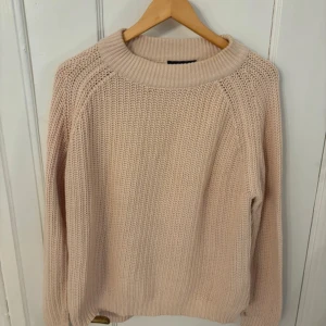 Beige stickad tröja från Selected Femme - Mysig beige stickad tröja från Selected Femme. Perfekt för kyliga dagar med sin bekväma passform och ribbade detaljer vid hals och ärmslut.