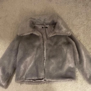 Grå pälsjacka från Gina Tricot - LÅNAD BILD!! Av tjejen jag köpte jackan av, jag säljer den då den inte kommer till användning, bara testad sen jag köpte den och finns inga skavanker eller liknande (som jag märkt av då jag inte använt den). Pris kan diskuteras🥰