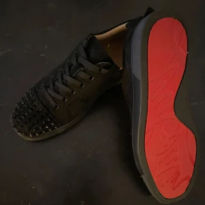 Svarta Louboutins med Spikar - Snygga svarta Christian Louboutins med ikonisk röd sula och Spikar I   ‼️NYSKICK‼️. Skorna har snörning och är tillverkade i skinn, vilket ger en lyxig känsla. Perfekta för den som vill sticka ut med stil. PRISET KAN DISKUTERAS 