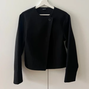 Svart kappa från Gina Tricot - Oanvänd kappa från Gina tricot. Så fin med en knapp som man knäpper med upptill. Nypris 500kr