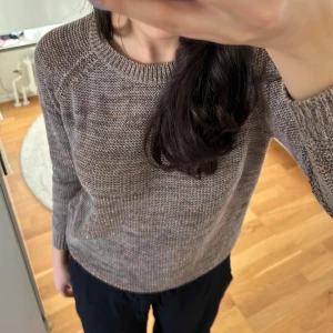 Brun glittrig stickad tröja från Havana - Säljer en mysig brun stickad tröja från Havana. Tröjan har långa ärmar och en klassisk rund halsringning. Perfekt för kyligare dagar och ger en stilren look.