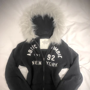mörkblå abercrombie&fitch zip up - handsydd därav FAST pris! OBSERVERA att nackdelar förekommer. framför allt ser man hur koftan har blivit sydd på baksidan då luvan består av ett tjockare lager vilket påverkade själva sydden. däremot syns detta inte när man har på sig koftan, med andra ord påverkar det inte utseendet. 💝med anledning till detta säljs det för billigare än vanligt! storlek S men passar även XS! handtvätt gäller då tvättmaskin + torktumlare förstör pälsen! 
