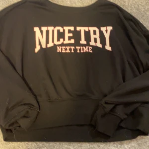 Svart tröja från FB Sister - Säljer en svart tröja från FB Sister med texten 'NICE TRY NEXT TIME' i vitt på framsidan. Tröjan har långa ärmar och en avslappnad passform. Perfekt för en casual look.
