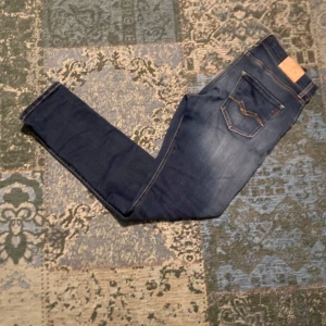 Mörkblå jeans från Replay - Snygga mörkblå jeans från Replay med en klassisk femficksdesign. De har en slim passform och är tillverkade i ett stretchigt material för extra komfort. Perfekta för en stilren look. 