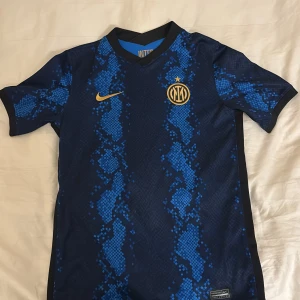 Inter hemma tröja 21/22 - Inter hemma tröja med ingen namn där bak. Köpt från Nike (ingen tryck) kan diskutera pris. Storlek L för barn