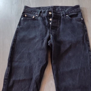 Svarta jeans från Sweet SKTBS - Snygga svarta jeans från Sweet SKTBS med knappgylf och klassisk femficksdesign. Perfekta för en stilren look. Märkeslapp i läder baktill ger en extra touch.