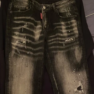 Svarta jeans från Dsquared2 - Snygga svarta jeans från Dsquared2 med slitna detaljer och en cool, blekt look. Byxorna är storlek 30/30.