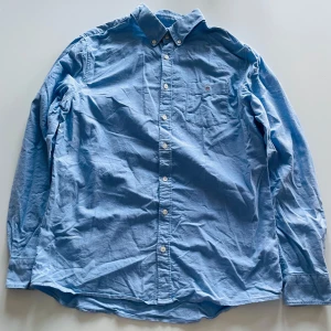 Blå skjorta från GANT - Säljer en klassisk blå skjorta från GANT i storlek 158/164. Använd 2 gånger och har bara legat i lådan under några år