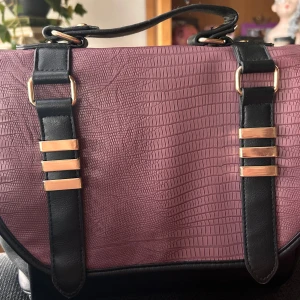 Stor axelremsväska från Deichmann! - Stor axelremsväska med snygga detaljer, handtag, trycknapp, justerbar axelrem, dragkedja, fräckt foder och flera små fack från Deichmann. Mått: 40 x 25 cm. Som ny!