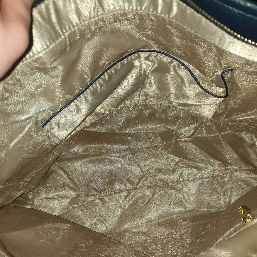 Helt ny axelbandsväska från Michael Kors. Väskan är marinblå med guldigt mönster. Fått i present så kan inte svara på äktheten. Mått 42×29. Se bilder💗. Laukut & Käsilaukut.