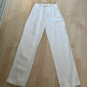 Vita linnebyxor - Snygga och bekväma vita linnebyxor. Perfekta för en avslappnad stil. Byxorna har en straight passform och är tillverkade i ett lätt och luftigt material. Dem ser lite ut som alobhas linnebyxor