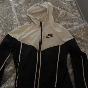 Svart och vit vindjacka från Nike - Lite smink fläckar inne i jackan, de går nog o få bort.