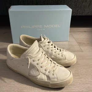 Philippe Model skor - Säljer ett par vita Philippe model sneakers i storlek 42. Skorna är använda men i bra skick.