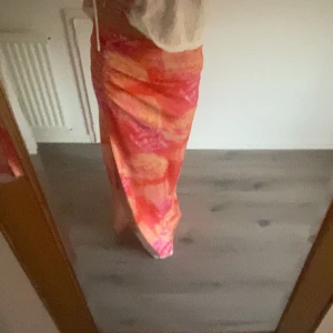 Färgglad långkjol från Gina Tricot💕💕 - Säljer en färgglad långkjol från Gina Tricot med ett livfullt mönster i orange och rosa nyanser. Kjolen har en smickrande passform och är perfekt för att lysa upp garderoben. Den är tillverkad i ett lätt och bekvämt materia med en slits på sidan!. Super fin kjol bara använd en gång!💕💕🥰🥰