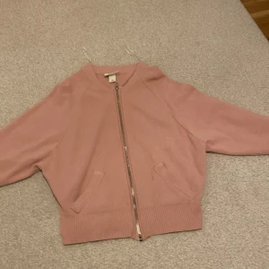 Rosa bomberjacka från Monki - Säljer en söt rosa bomberjacka från Monki i storlek XS. Jackan har en dragkedja framtill och ribbade muddar vid ärmslut och nederkant. Perfekt för en avslappnad stil.