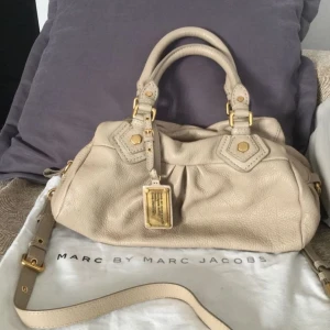 Marc Jacobs väska  - Jätte fint läderväska från Marc Jacobs i den populära mini modellen😍 Väskan är vintage men är fortfarande i jätte fint skick, enda defekter som finns är lite smutsig inuti och ena handtaget har lite fläckar (se bild 5)🩷 Skriv för mer info🫶🏻