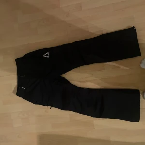Svarta skidbyxor från Slade Couture - Snygga svarta byxor från Slade Couture med en stilren design. Byxorna är perfekta i backen! Använda fem gånger och nästan ny skick!
