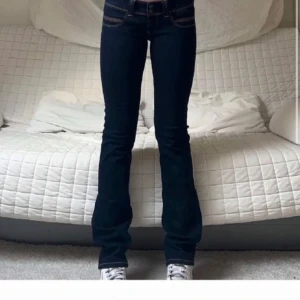 Mörkblå bootcut jeans - Snygga mörkblå bootcut jeans med låg midja och klassisk femficksdesign. Perfekta för en avslappnad stil med en touch av retro. Passar bra med sneakers eller klackar för en mer dressad look. W31 L34. Dom är små i storleken och passar mig som är en 27-28 