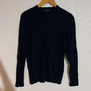 Svart tröja från Zara - Säljer en stilren svart tröja från Zara i storlek S. Tröjan har en klassisk design med långa ärmar och en v-ringad hals. Perfekt för en minimalistisk look.