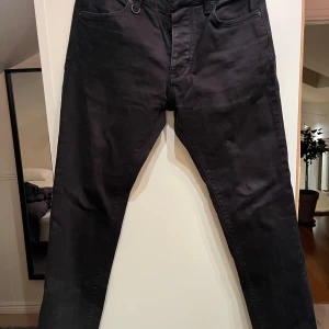 Svarta jeans från Neuw - Snygga svarta jeans från Neuw med en klassisk design. De har en normal passform och är perfekta för en stilren look. Jeansen har fem fickor och en knappgylf. Uppsydda så mer likt 30 i längd.