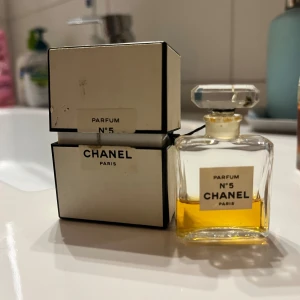 Chanel N°5 Parfum - Parfymolja  - Nypris: 2800kr. Elegant och tidlös Chanel N°5 Parfum i en klassisk glasflaska med en stilren etikett. Parfymen kommer i en vit och svart kartongförpackning. Perfekt för den som älskar lyx och klassisk doft. 
