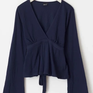 Mörkblå tröja med v-ringning - Mörkblå topp från gina med v-ringning och långa ärmar. Aldrig använd och prislappen kvar!