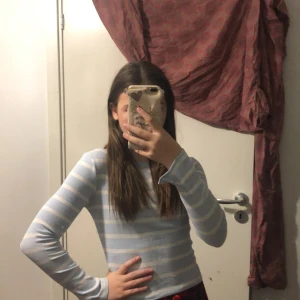 Ljusblå och vit randig tröja från Kappahl - Säljer en ljusblå och vit randig tröja från Kappahl. Tröjan har långa ärmar och är perfekt för en avslappnad stil. Den är gjord i mjukt material och passar bra till vardags.