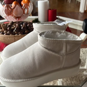 Vita varmfodrade boots - Helt oanvända! Säljer ett par vita boots med varm fodring. De har en enkel design med rund tå och en bekväm sula. Perfekta för kalla dagar.
