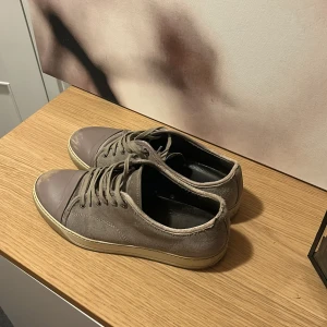 Lanvin skor - Snygga grå sneakers från Lanvin. Lite slitningar på tån därav priset annars inget större fel förutom lite slitningar runt öppningen på skon