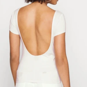 VIT  topp med öppen rygg - Snygg VIT topp med djup öppen rygg och korta ärmar. Perfekt för en stilren och elegant look. Har bild på den svarta eftersom jag har kvar bilden från innan men säljer i vitt.