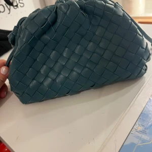 Blå flätad axelväska - Intressekoll på min jätte fina handväska. Den köptes i somras men jag kollar endast intresse för att se vad jag kan få för den.  Den är i 100 % vegansk läder . Den är i bra skick rymmer mycket!!  Man kan skystera bandet så de blir längre eller kortare. Skriv om du har någon fråga   eller fundering ♥️