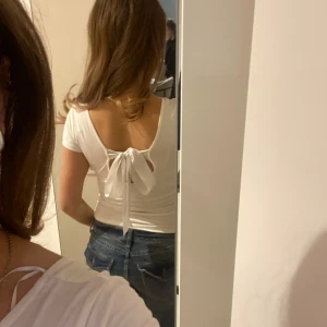 Vit topp med knytning  - Säljer denna vita topp från 157 med korta ärmar och snygg knytning i ryggen.  Använd en gång